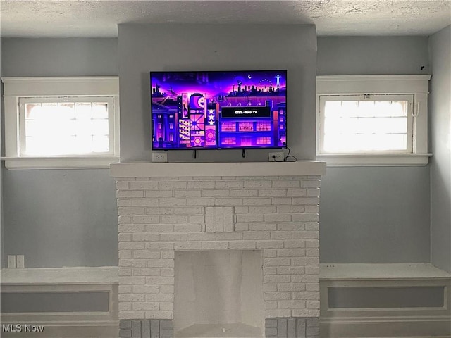 details featuring a brick fireplace and a textured ceiling