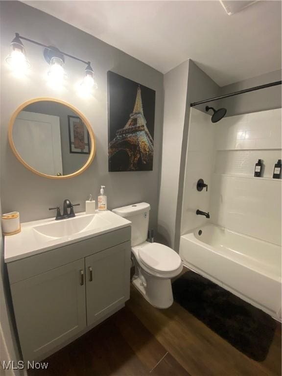 full bathroom featuring hardwood / wood-style flooring, toilet, vanity, and  shower combination