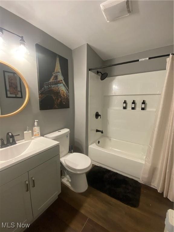 full bathroom featuring wood-type flooring, vanity, shower / tub combo with curtain, and toilet