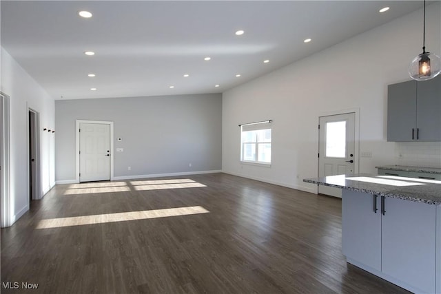 unfurnished living room with vaulted ceiling and dark hardwood / wood-style floors