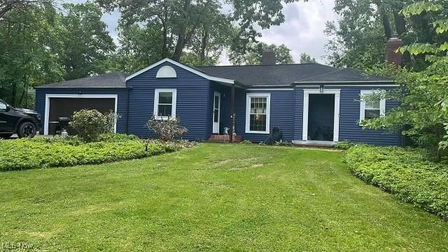 view of front of house with a garage and a front lawn