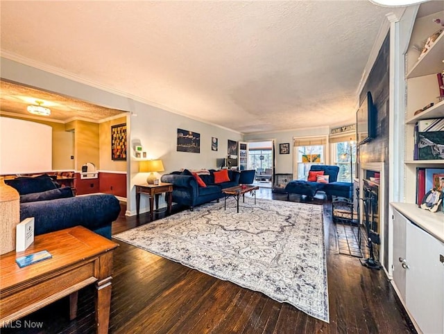 living room with a fireplace, ornamental molding, dark hardwood / wood-style floors, and a textured ceiling