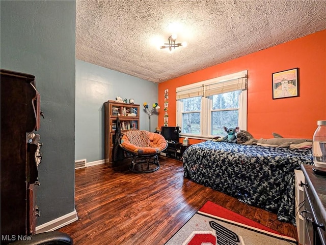 bedroom with hardwood / wood-style floors and a textured ceiling