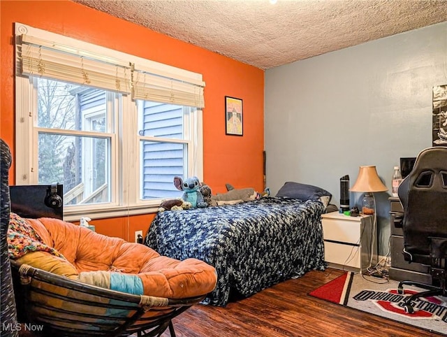 bedroom featuring hardwood / wood-style flooring and a textured ceiling