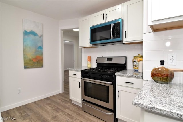 kitchen with decorative backsplash, appliances with stainless steel finishes, and white cabinets