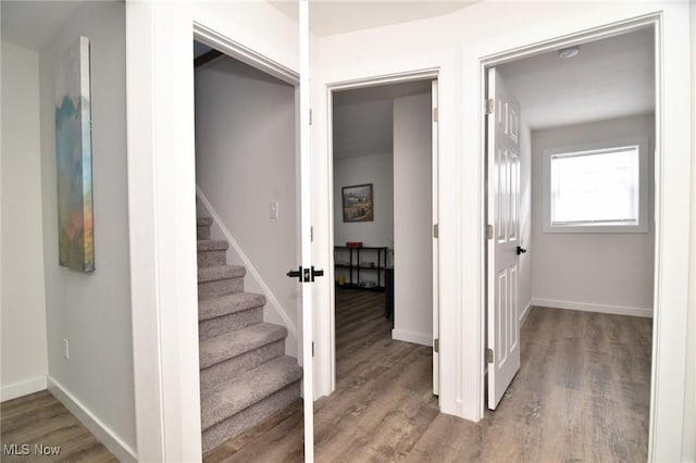 staircase with baseboards and wood finished floors