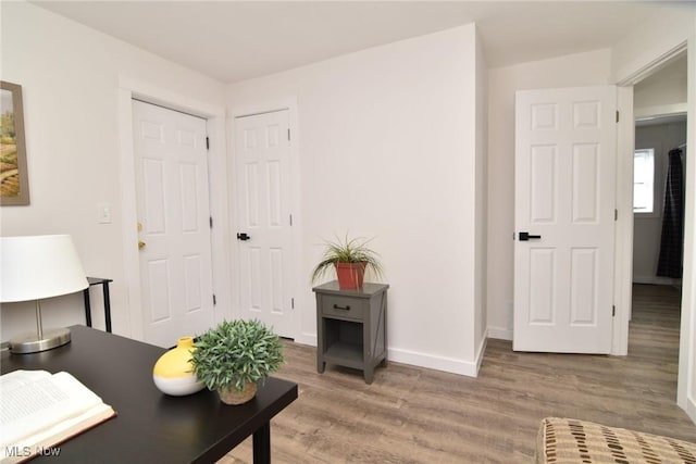 office space featuring light wood-type flooring and baseboards