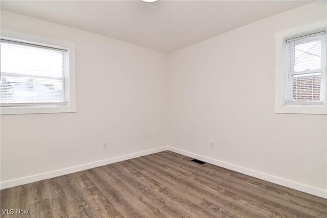 spare room with wood finished floors and baseboards