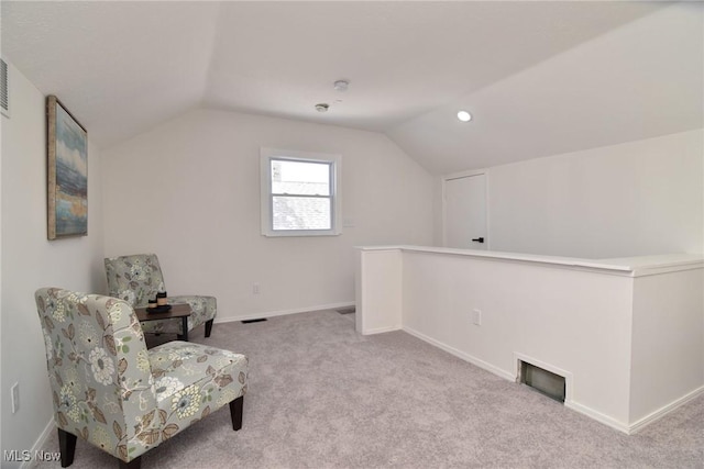 sitting room with visible vents, baseboards, lofted ceiling, and carpet floors