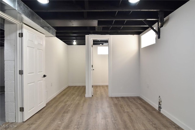 below grade area with light wood-style flooring and baseboards