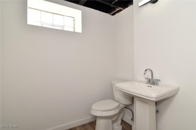 bathroom featuring toilet, baseboards, and wood finished floors