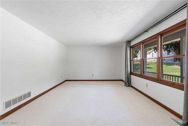 unfurnished room featuring carpet floors and a textured ceiling