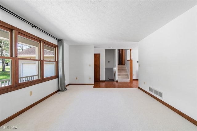 carpeted spare room with a textured ceiling