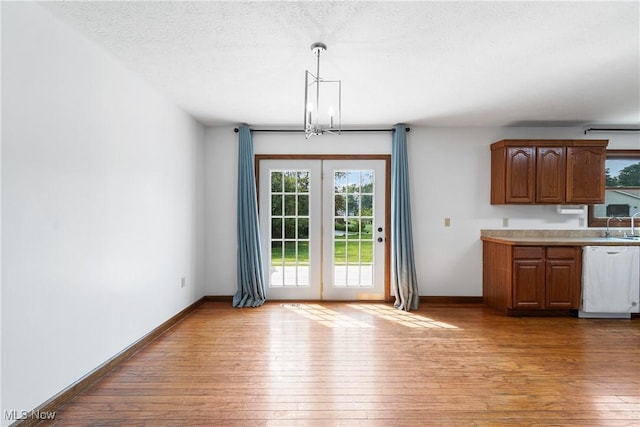 interior space featuring a notable chandelier, sink, a textured ceiling, and light hardwood / wood-style floors