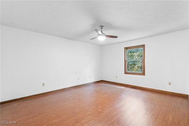 spare room with hardwood / wood-style flooring and ceiling fan