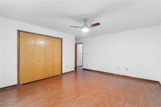 unfurnished bedroom featuring hardwood / wood-style flooring, ceiling fan, and a closet