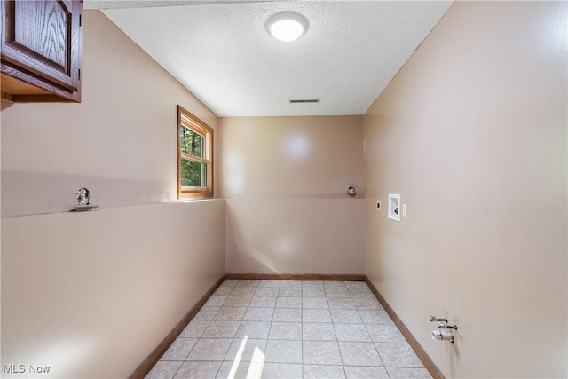 laundry area with gas dryer hookup, cabinets, washer hookup, and a textured ceiling