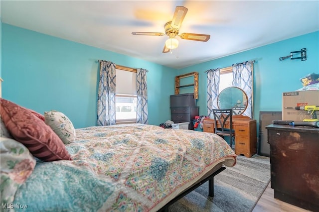 bedroom with multiple windows, ceiling fan, and light hardwood / wood-style flooring