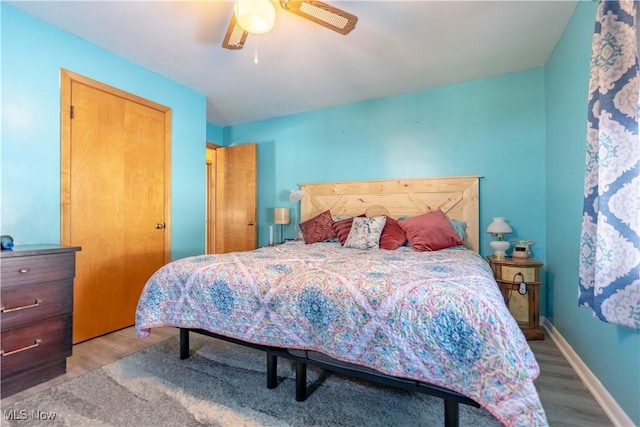 bedroom with ceiling fan, light hardwood / wood-style floors, and a closet