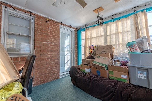 interior space with brick wall, plenty of natural light, and carpet floors