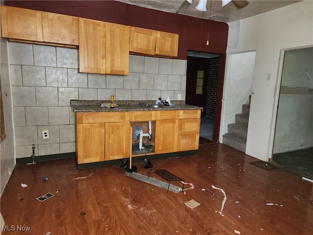 kitchen with tasteful backsplash, dark hardwood / wood-style flooring, and dark stone countertops