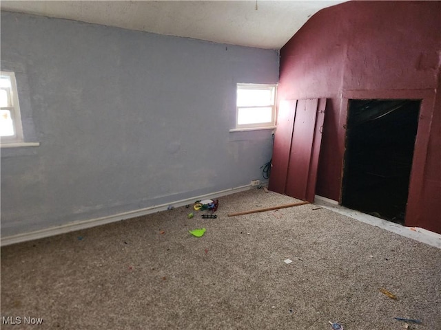 unfurnished room featuring vaulted ceiling