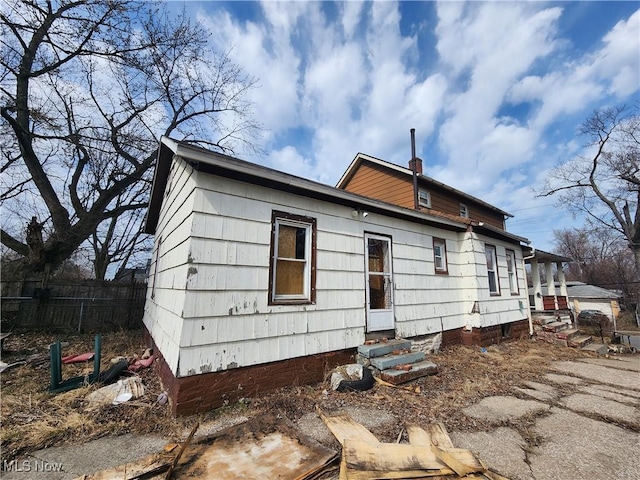 exterior space featuring fence, a chimney, and entry steps