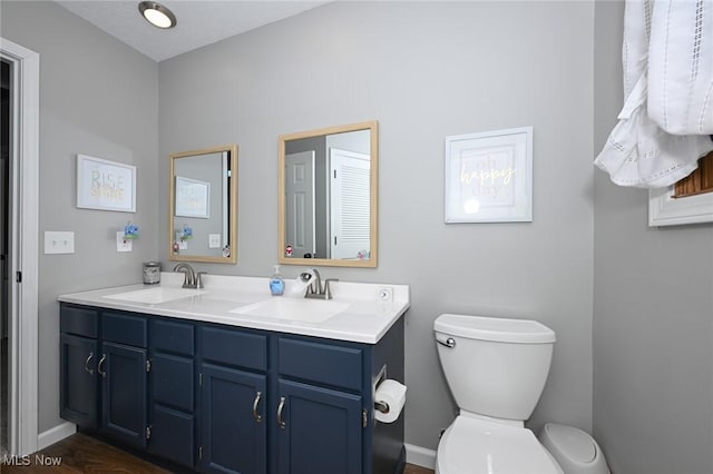 bathroom featuring vanity, hardwood / wood-style flooring, and toilet