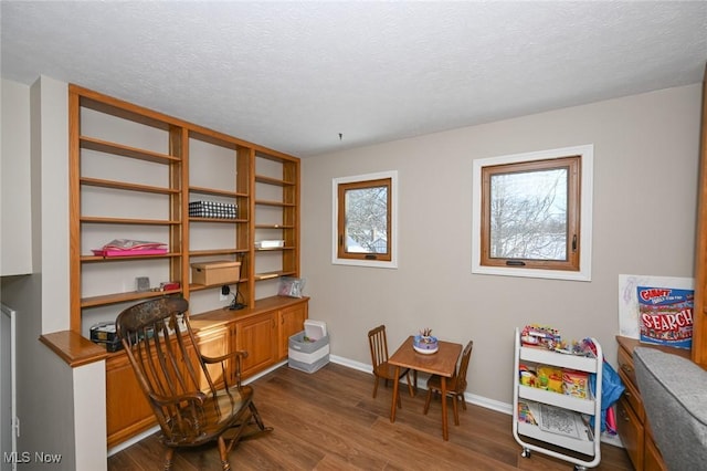 office area with hardwood / wood-style flooring, built in desk, and a textured ceiling