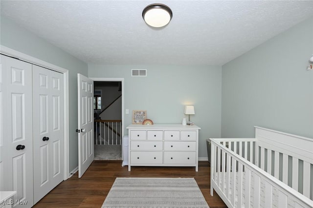 bedroom with dark wood-type flooring, a closet, and a textured ceiling