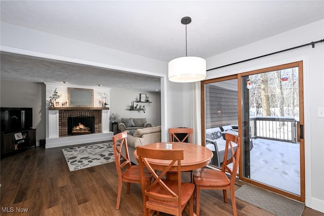 dining room featuring a fireplace and dark hardwood / wood-style floors