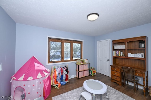 playroom featuring dark hardwood / wood-style floors and a textured ceiling