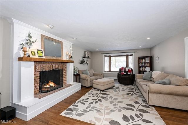 living room with dark wood-type flooring and a fireplace