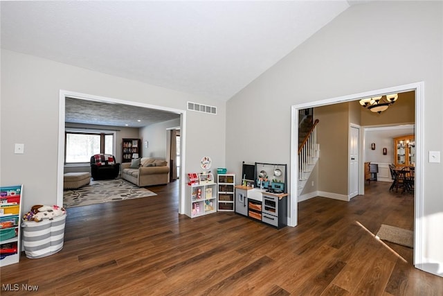 interior space with lofted ceiling, dark hardwood / wood-style floors, and an inviting chandelier