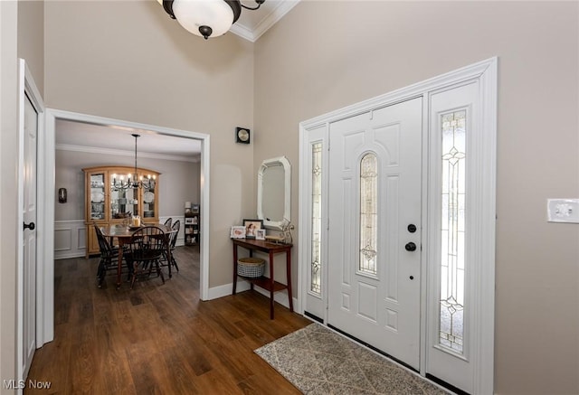 entryway with a notable chandelier, ornamental molding, and dark hardwood / wood-style floors