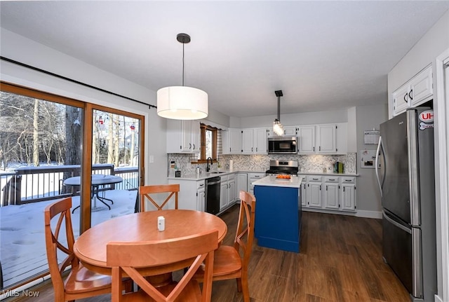 kitchen with white cabinetry, sink, stainless steel appliances, and a kitchen island