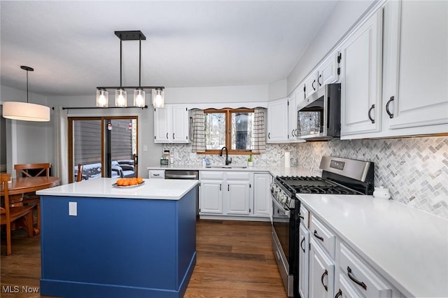 kitchen featuring pendant lighting, white cabinetry, stainless steel appliances, dark hardwood / wood-style floors, and a center island