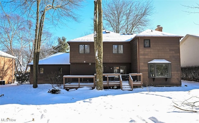 snow covered property with a wooden deck