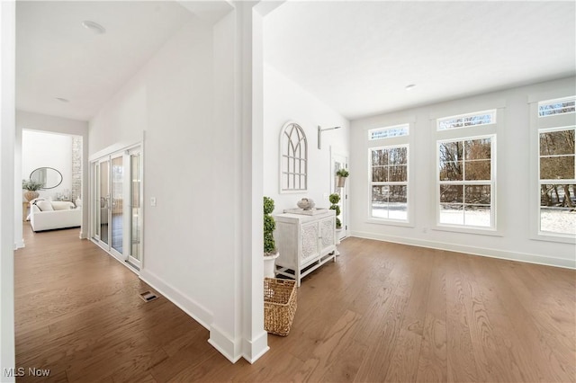 interior space with wood-type flooring and vaulted ceiling