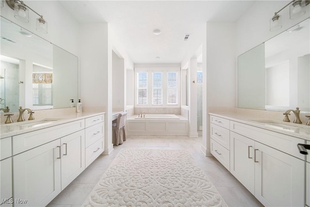 bathroom with tile patterned flooring, vanity, and shower with separate bathtub