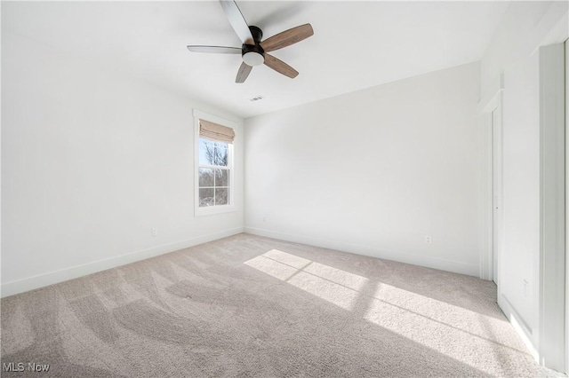 carpeted spare room with ceiling fan