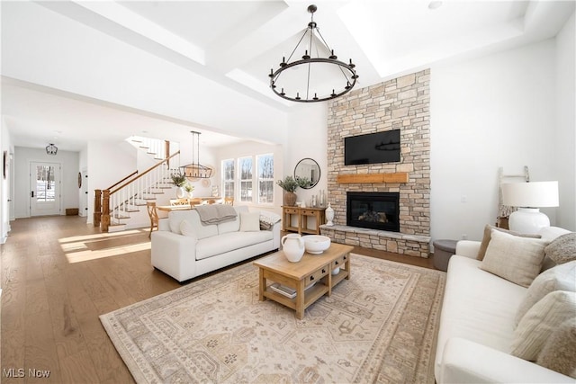 living room featuring hardwood / wood-style flooring, a notable chandelier, a fireplace, and a wealth of natural light