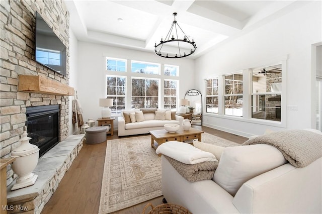 living room with coffered ceiling, hardwood / wood-style flooring, a fireplace, and a healthy amount of sunlight