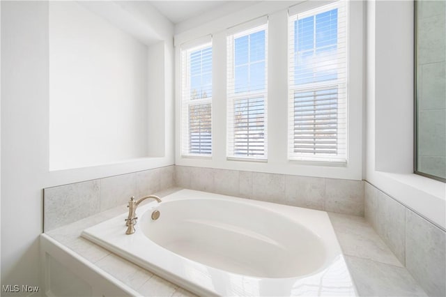 bathroom with a relaxing tiled tub