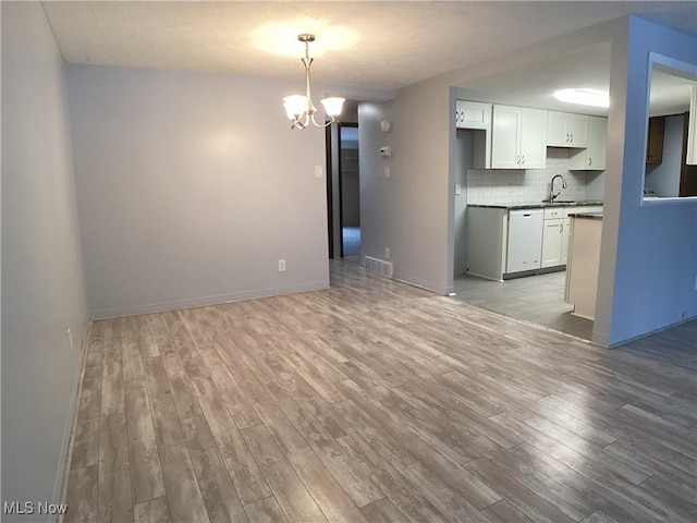 interior space featuring a chandelier, sink, and light wood-type flooring