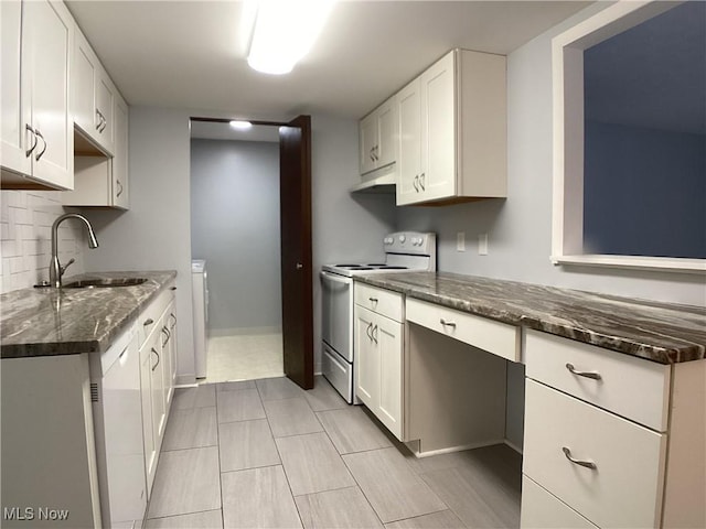 kitchen featuring dark stone countertops, white electric range oven, sink, and white cabinets