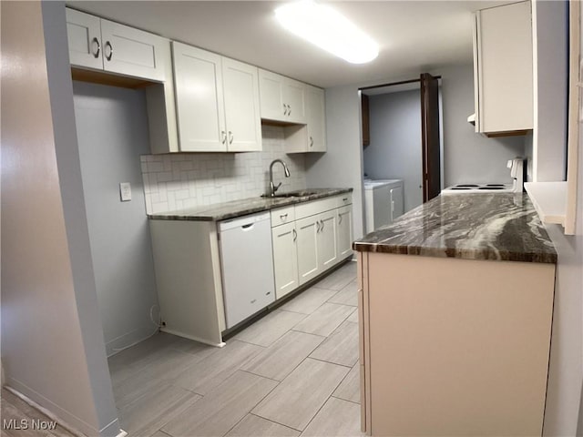 kitchen featuring washing machine and clothes dryer, sink, white cabinetry, range, and dishwasher