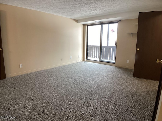 carpeted spare room featuring a textured ceiling