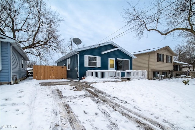 snow covered house featuring a porch