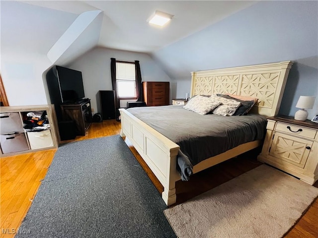 bedroom with hardwood / wood-style floors and vaulted ceiling